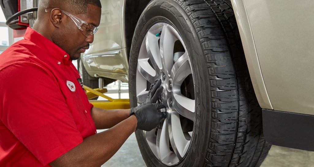 A Big O Tires employee changing a tire