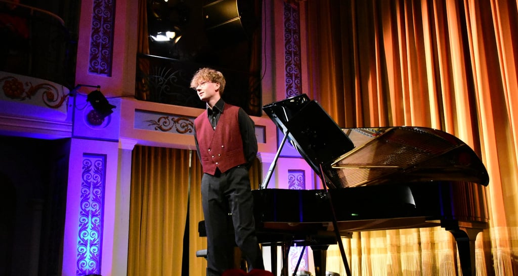 a man in a red shirt and tie dye on a stage