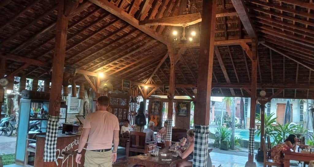 a man and woman standing in a hut with a dog