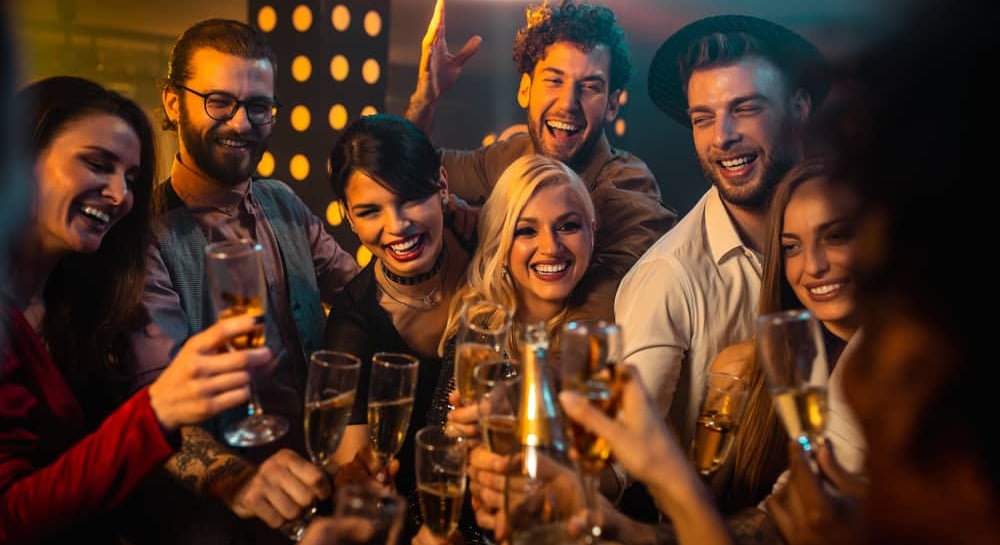 Group of friends toasting with champagne at a lively Las Vegas nightclub, enjoying a festive night out.