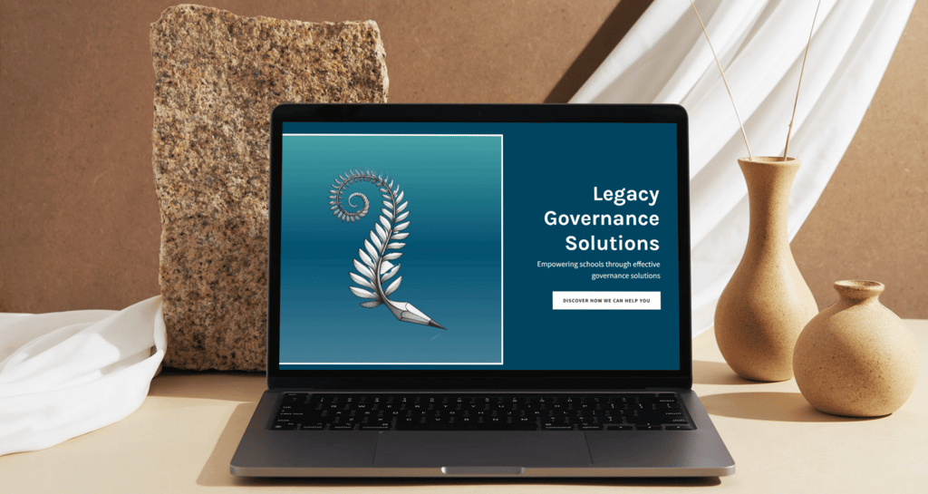 a laptop computer sitting on a table with a vase with the website legacy governance solutions on it