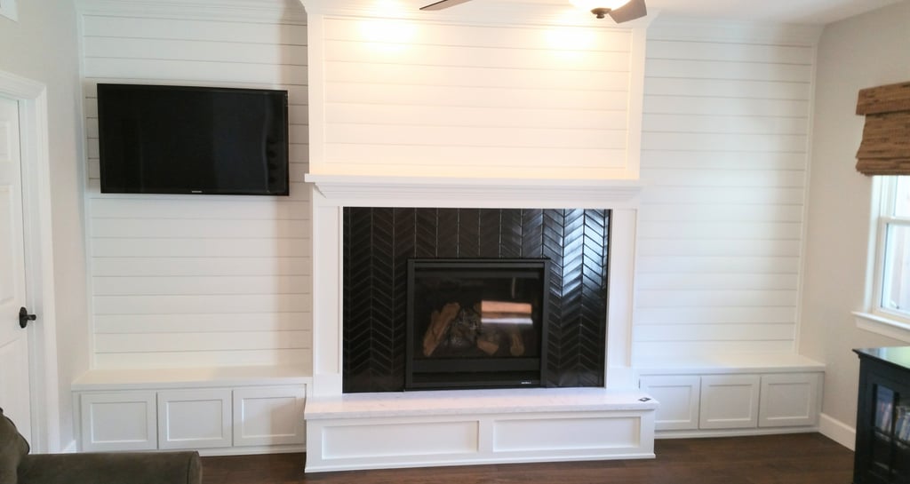 fireplace surround in black tile in a herring bone pattern.  White wood work and mantle. Colorado Springs custom fireplaces.