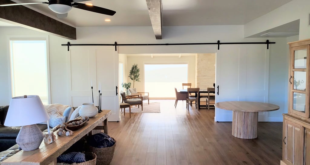 living room into dining room with custom sliding barn doors to separate.  custom beams on the ceiling. Colorado Springs.