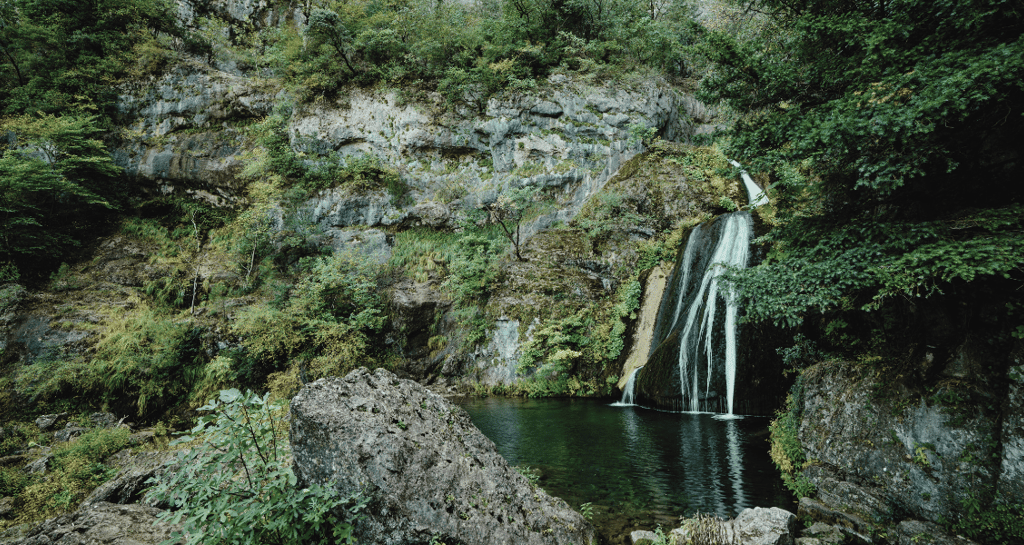 a waterfall in a canyon with a waterfall in the background