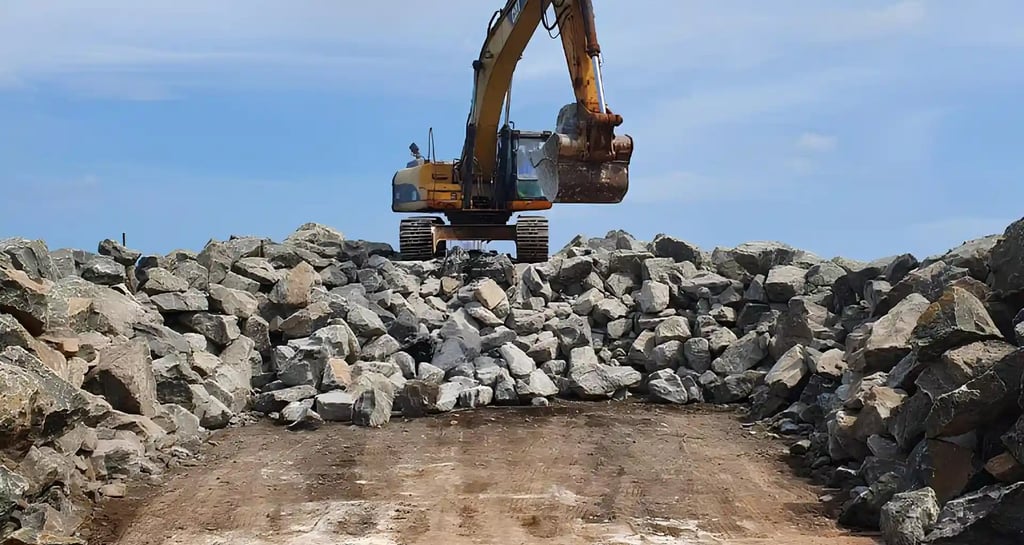 a large pile of rocks boulder and a bulldozer
