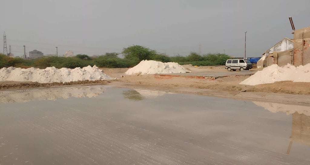 a truck parked in front of a pile of salt