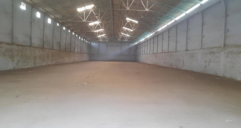 a large warehouse space with a large open space for people to sit and talk and store freight goods