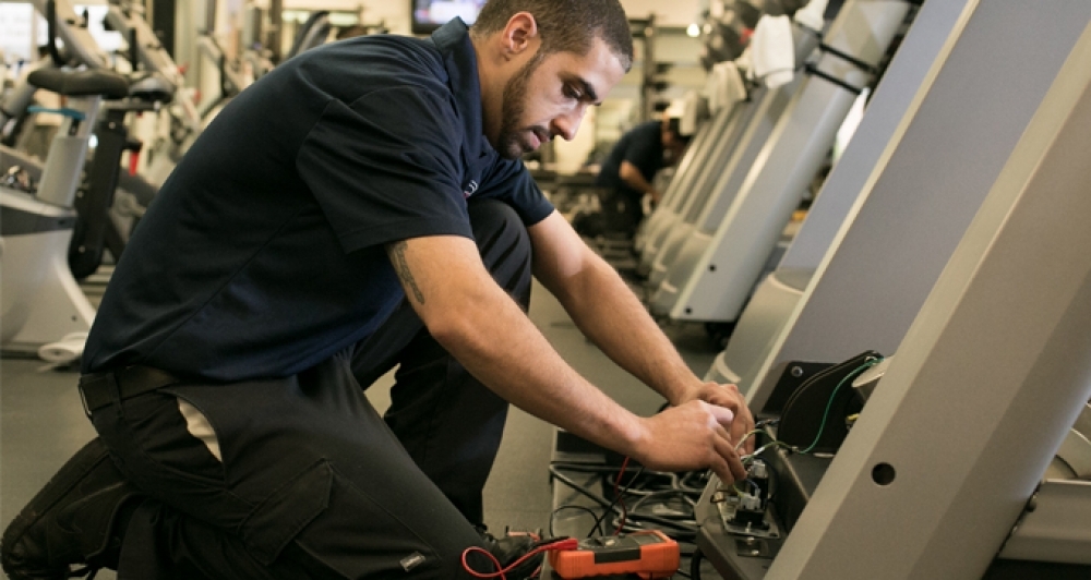 a man in a gym room with a bike