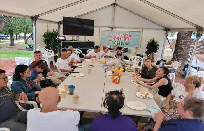 a group of people sitting around a table - outdoor gathering