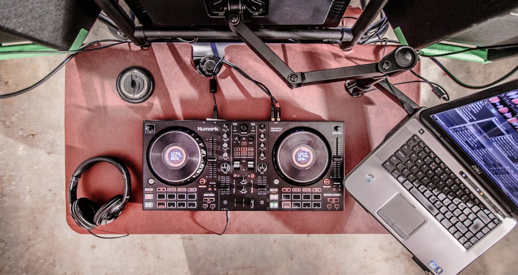 Top-down view of a professional DJ controller, laptop, and headphones on a mobile Dj Buggy