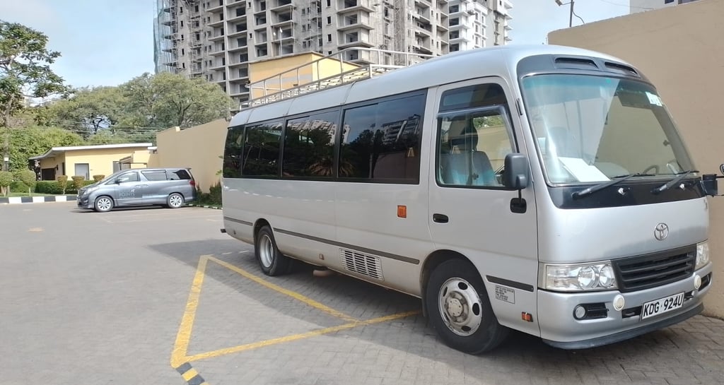 Toyota Coaster minibus parked ready for corporate staff transportation