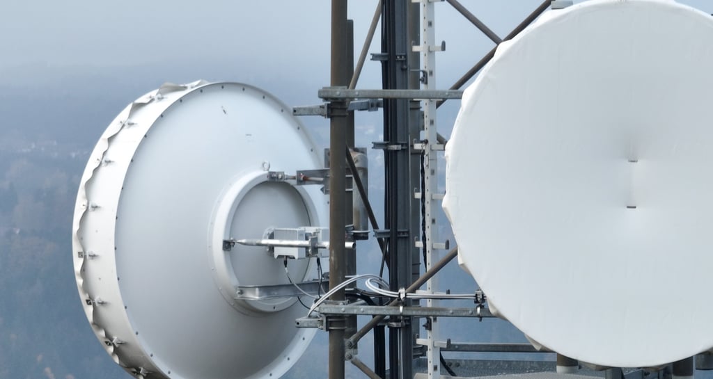 Close-up of microwave point-to-point radio link antennas on a telecommunications tower.