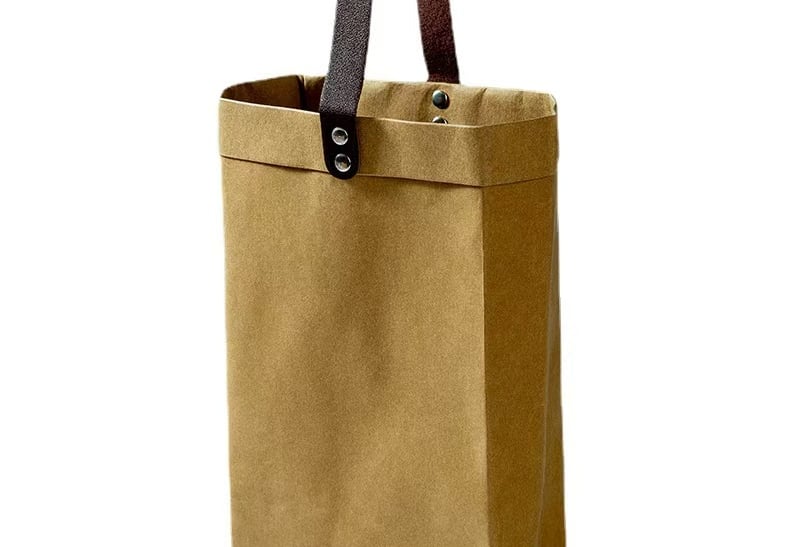 a brown washable paper bag with a brown leather handle