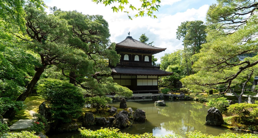Traditional Japanese temple with pagoda roof amidst lush greenery, illustrating Japan's cultural