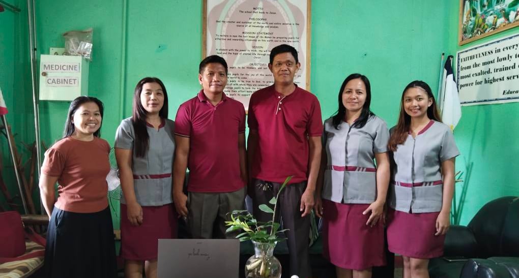 a group of people standing in front of a laptop