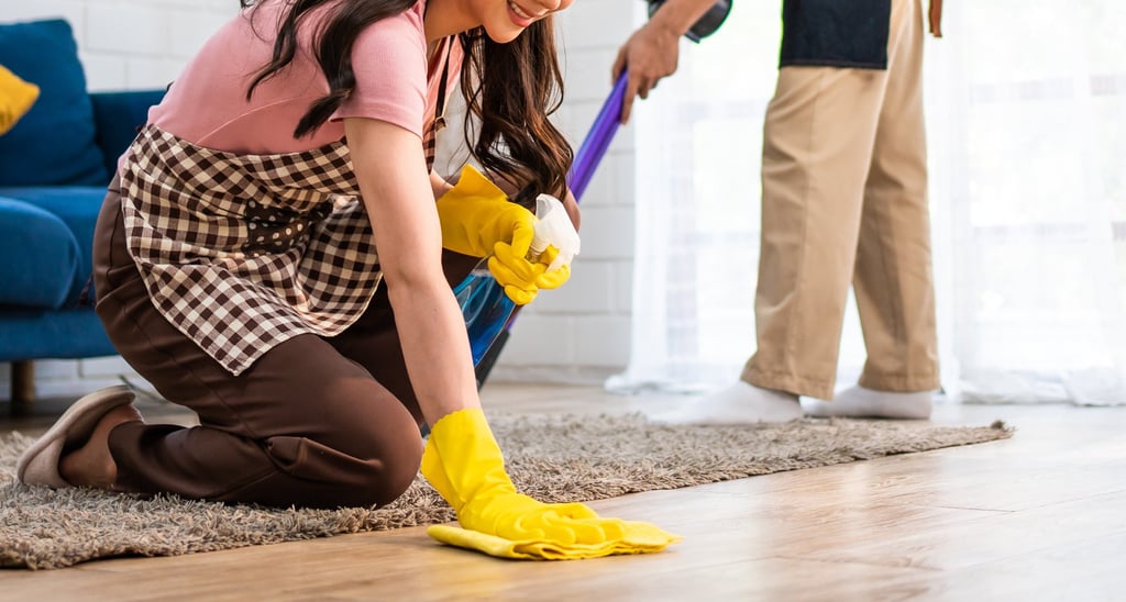 a man and woman cleaning a living room