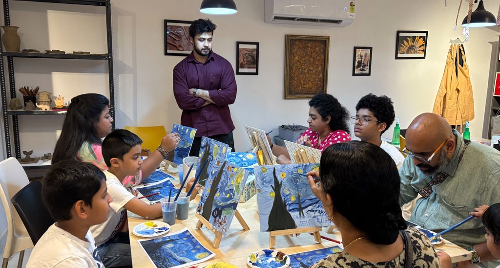 A group of people attending a painting workshop, creating Van Gogh inspired starry nigh on canvases.