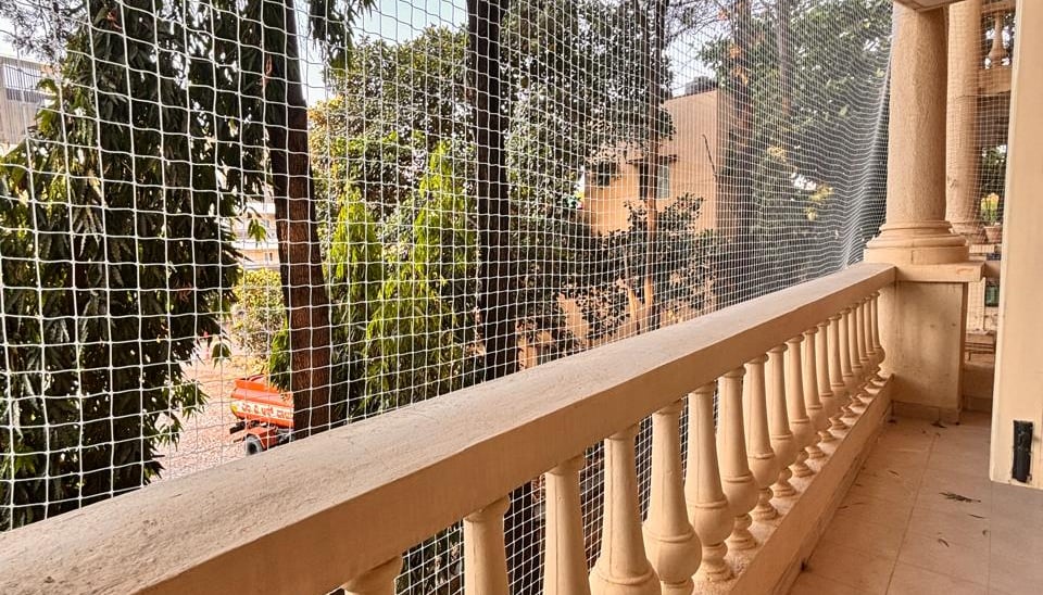 Close-up of a freshly installed pigeon safety net tightly secured on a balcony in Yelahanka.