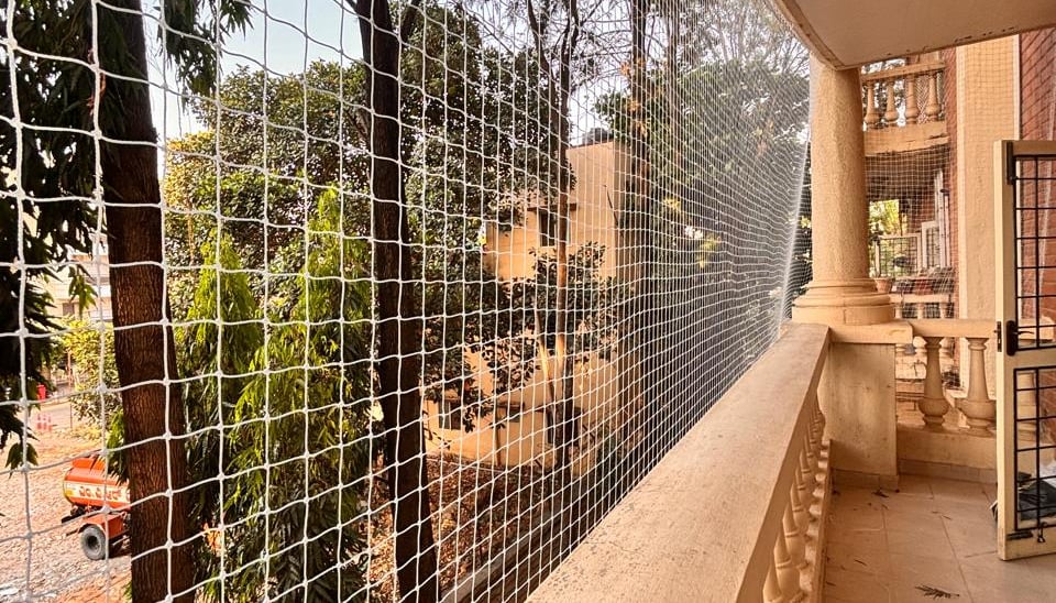Close-up of a sturdy pigeon net tightly installed on a balcony railing in Bangalore.