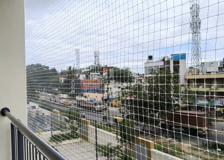 Close-up of a sturdy anti-pigeon net installed on a balcony railing in Nungambakkam.