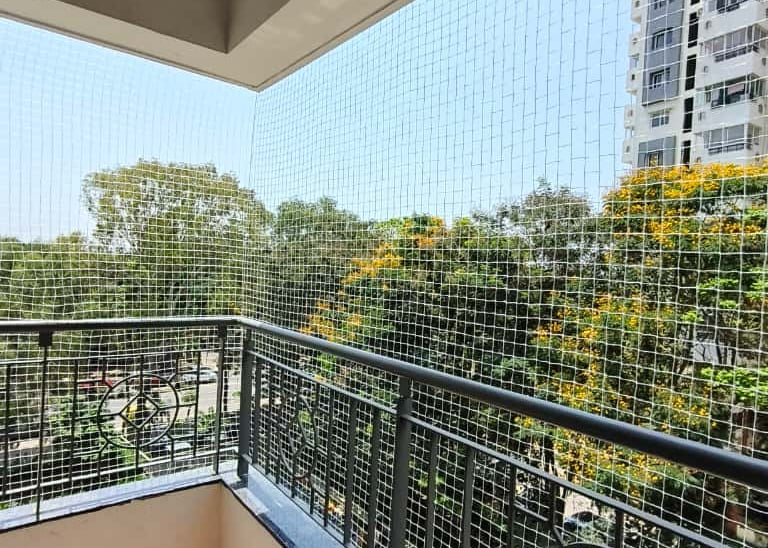 Close-up of a sturdy balcony safety net installed on a residential balcony in Sholinganallur.