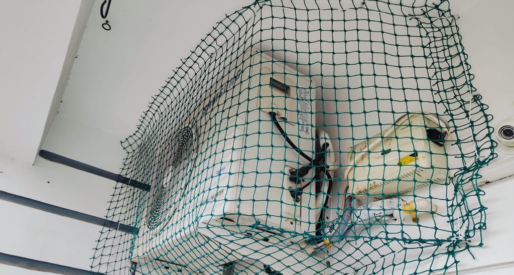 Close-up of a sturdy balcony pigeon net tightly secured on a Pallavaram apartment balcony.