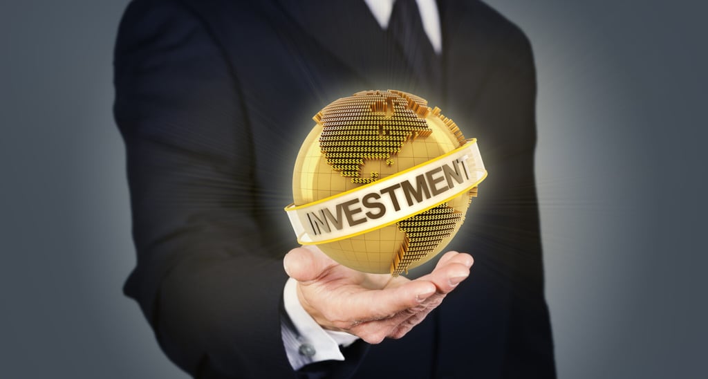 'investment', text by a sturdy man holding the globe, showing scope across it for customers