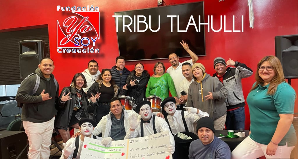 Tribu Tlahuilli community group with mimes and drum set posing in front of a red wall.