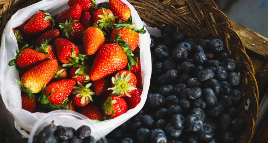 Fresh blueberries and strawberries in ceramic bowls as low-glycemic fruits for people with diabetes.