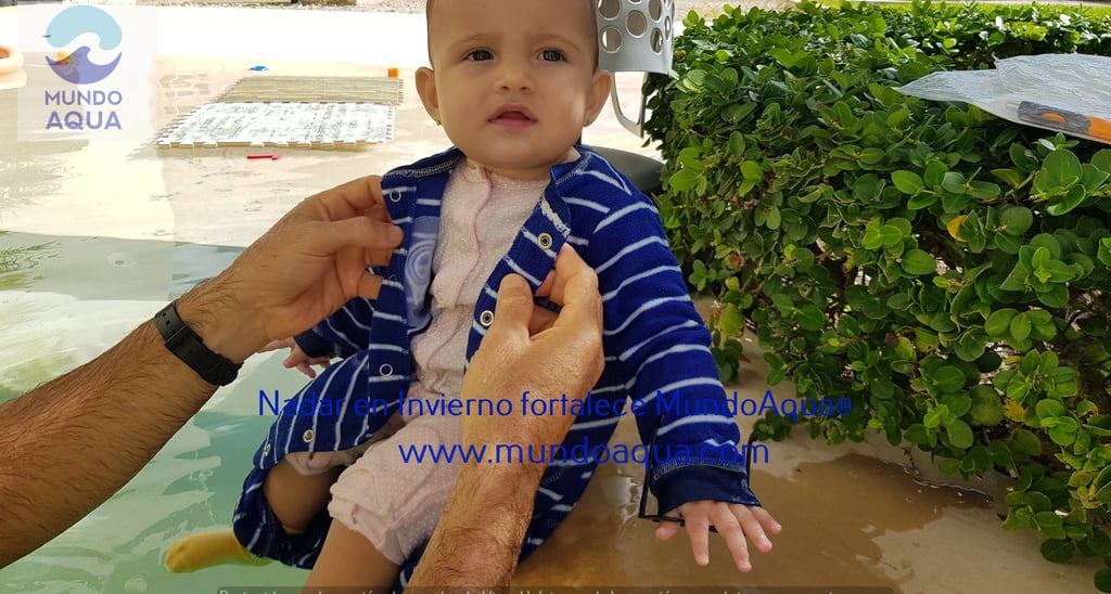 a baby in a blue jacket is being held by a man