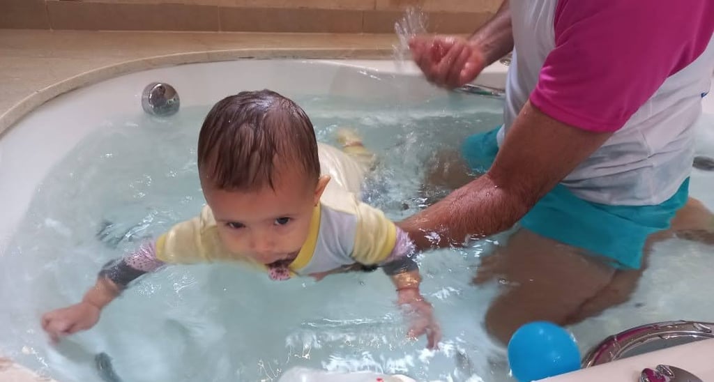 a baby in a tub with a man in a bathtub