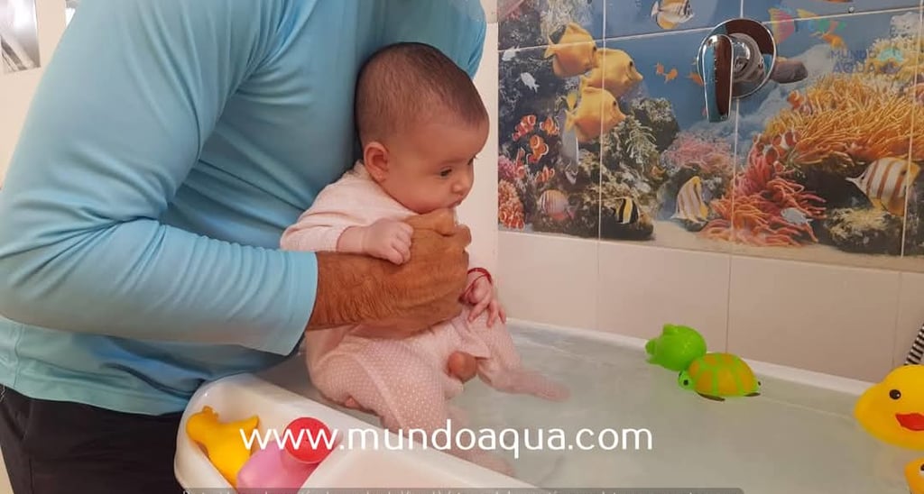a man holding a baby in a bathtub