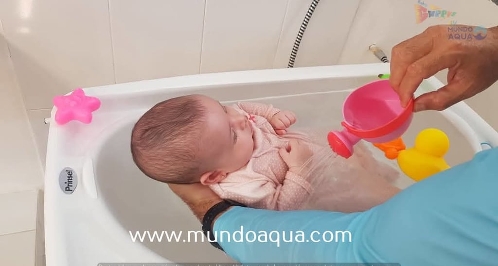 a baby in a tub with a man holding a pink cup