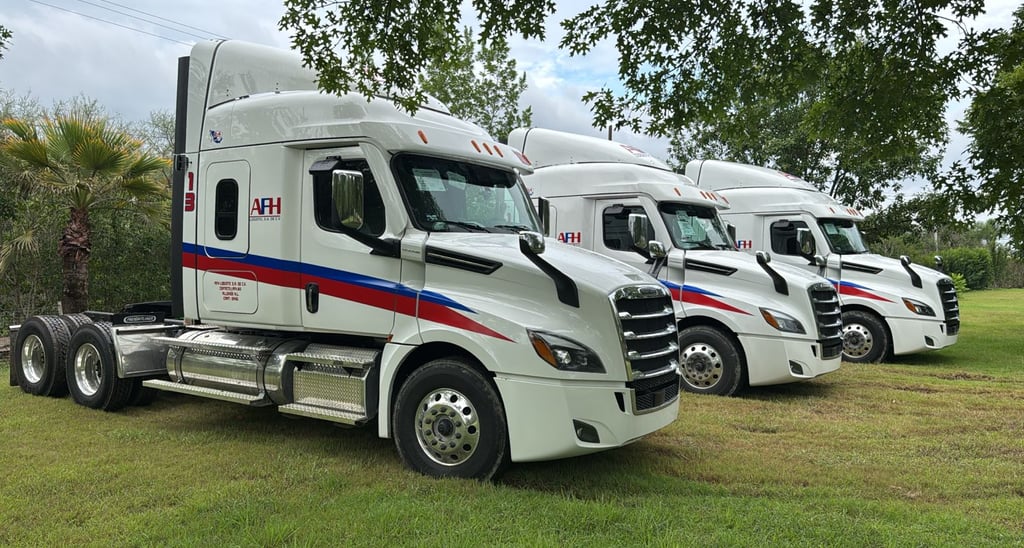 Flota de camiones AFH Logistics alineados en un campo verde en Allende, Nuevo León