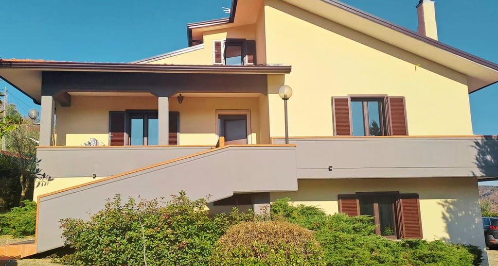 a house with a staircase leading up to a large balcony