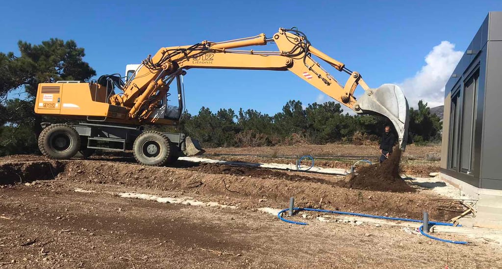 Εκσκαφέας πραγματοποιεί χωματουργικές εργασίες σε κήπο