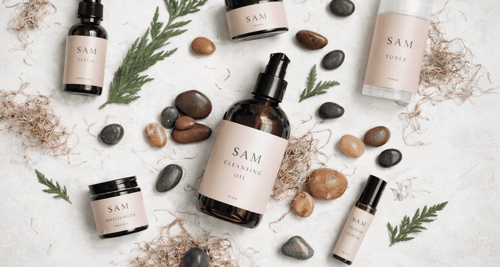 Línea de skincare natural de SAM Cosméticos con frascos, crema facial y tónico sobre fondo con hojas y piedras.