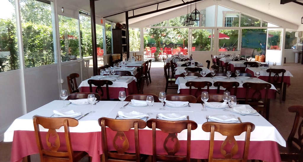 a restaurant with tables and chairs and a table with plates and glasses
