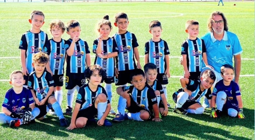 a group of young children soccer players posing for a picture