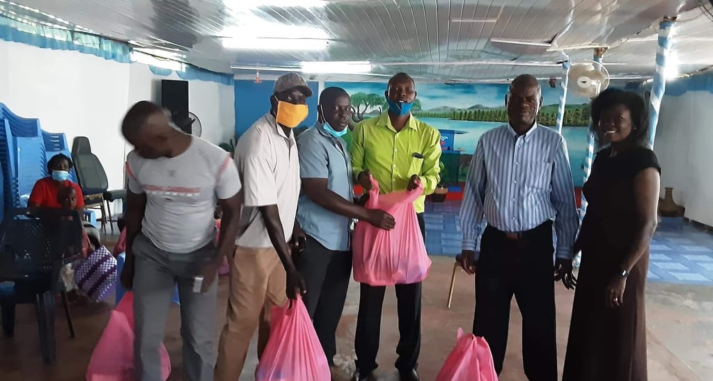 Volunteers distributing pink bags of food and supplies in Kisumu.