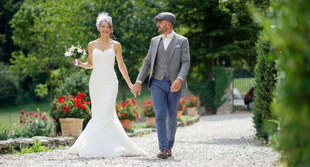Photo d'un mariage à Dijon avec les mariés souriants, marchant dans une allée mains dans la main.