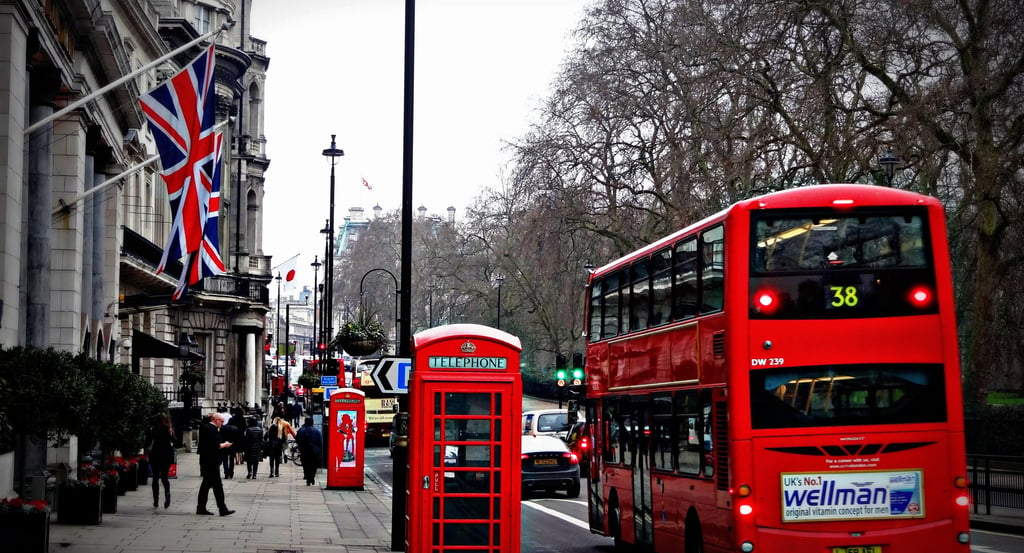 Un autobús rojo de dos pisos y las emblemáticas cabinas telefónicas rojas en una calle de Londres