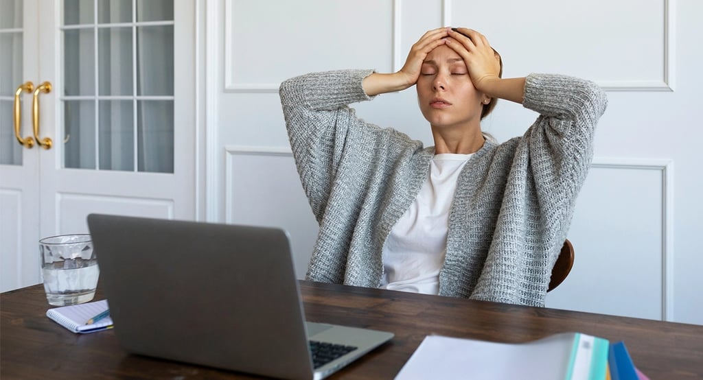 Mujer estresada frente a computadora
