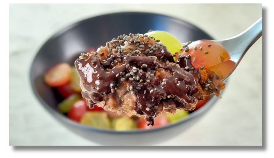 Chocolate porridge with grapes and dark chocolate — a warm, healthy Mediterranean breakfast.