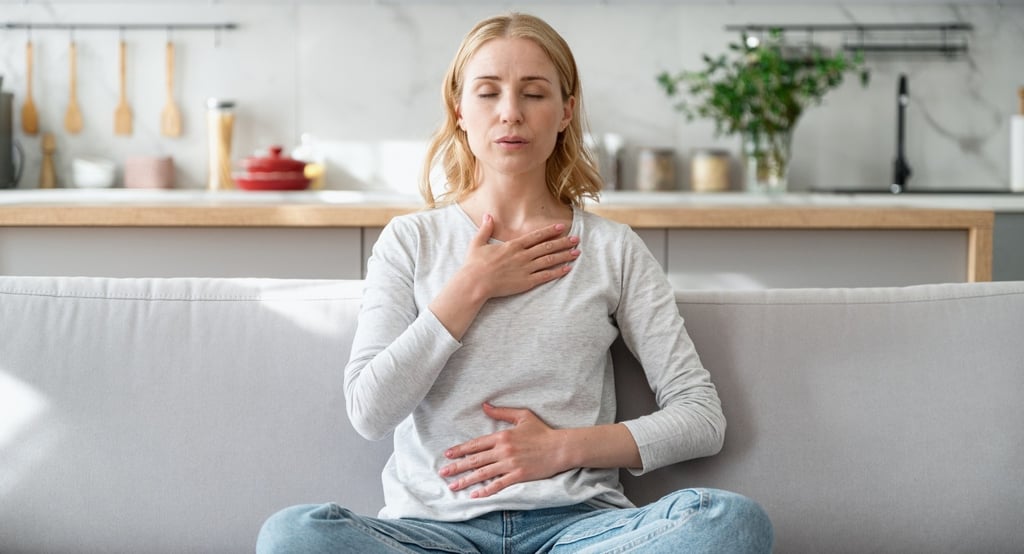 Woman sitting calmly with hands on chest and stomach, representing stress, hormone imbalance