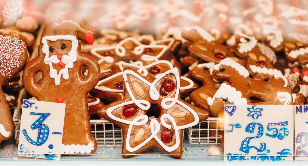 Decorated gingerbread cookies in Santa and star shapes at a European Christmas market stall.