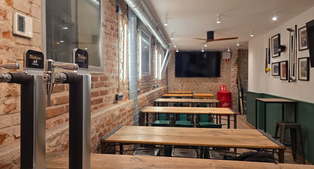 Sala de restaurante con mesas altas para ver el partido con un sonido envolvente sobre pantallas 