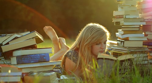 a woman laying on a pile of books