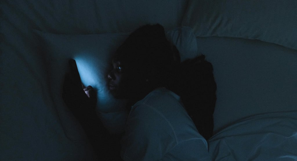 a person laying in bed with a cell phone