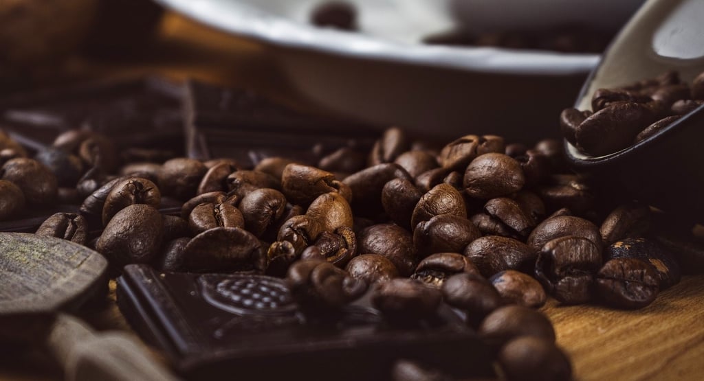Makrofotografie: Geröstete Kaffeebohnen und dunkle Schokolade auf Holz. Food Fotografie Metta-Macro